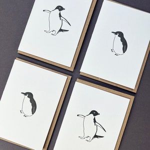 Peut inclure: Quatre cartes de vœux vierges avec des illustrations en noir et blanc de pingouins. Chaque carte présente un pingouin dans une pose différente.