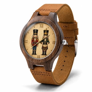 Könnte beinhalten: Eine Armbanduhr mit einem dunkelbraunen Holzgehäuse und einem beigen Lederarmband. Das Zifferblatt hat einen beigen Hintergrund mit zwei Nussknacker-Figuren, eine in Rot und eine in Grün, sowie schwarzen römischen Ziffern auf den Positionen zwölf, drei, sechs und neun.