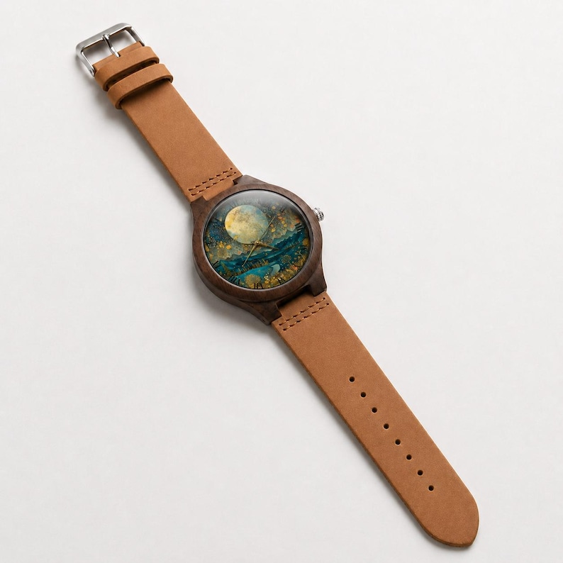 May include: A wristwatch with a dark brown wooden case and a light tan leather strap. The watch face features a detailed artistic illustration of a full moon in a dark blue and gold night sky, with thin gold-toned hands indicating the time.