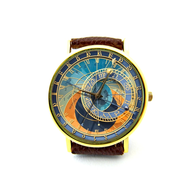 K&ouml;nnte beinhalten: Eine goldfarbene Armbanduhr mit einem braunen Lederarmband. Das Zifferblatt der Uhr zeigt ein blaues und orangefarbenes Design mit r&ouml;mischen Ziffern und einem kreisf&ouml;rmigen Muster.