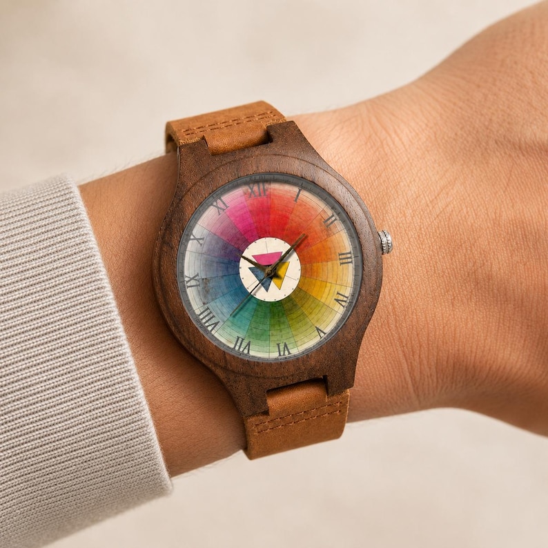 May include: A wristwatch with a dark brown wooden case and a tan leather strap. The watch face features a circular rainbow color wheel design with black Roman numerals and a central white circle containing two small overlapping triangles.