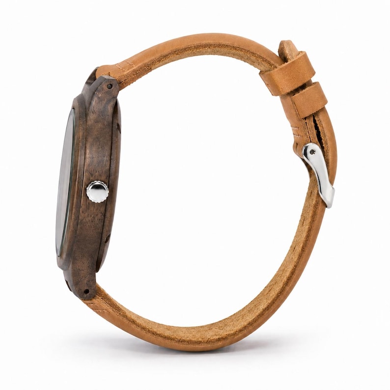 K&ouml;nnte beinhalten: Seitenansicht einer Armbanduhr mit einem braunen Holzgeh&auml;use und einem hellbraunen Lederarmband. Die Uhr hat eine silberfarbene Krone und Schnalle. Das Armband wird mit einem Schnallenverschluss befestigt. Das Zifferblatt ist sichtbar.