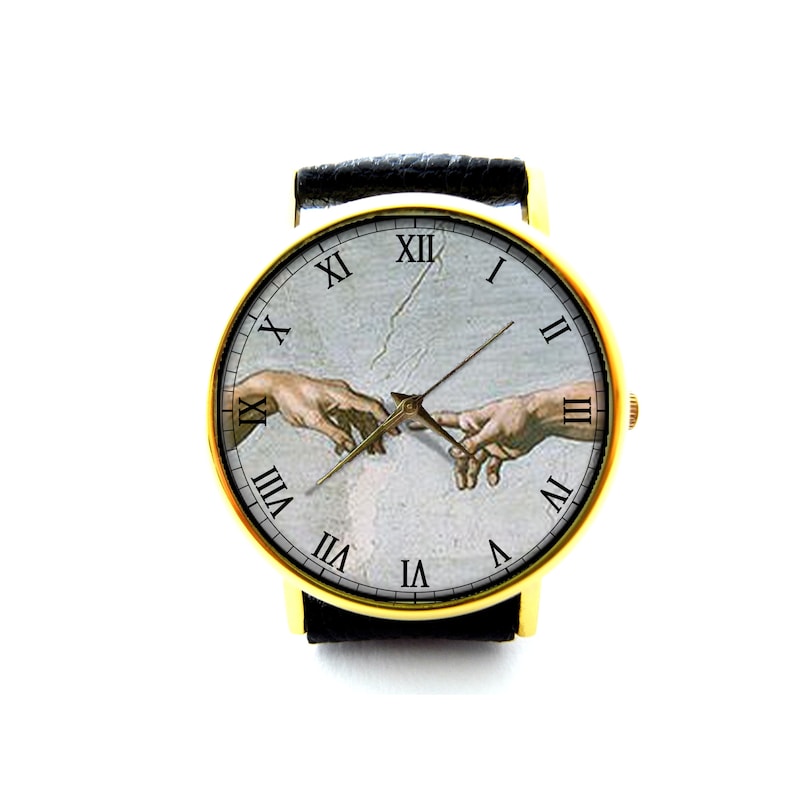 Pode incluir: Um rel&oacute;gio de pulso dourado com uma pulseira de couro preto. O mostrador do rel&oacute;gio apresenta uma reprodu&ccedil;&atilde;o da pintura de Michelangelo A Cria&ccedil;&atilde;o de Ad&atilde;o, com marcadores de hora em algarismos romanos.