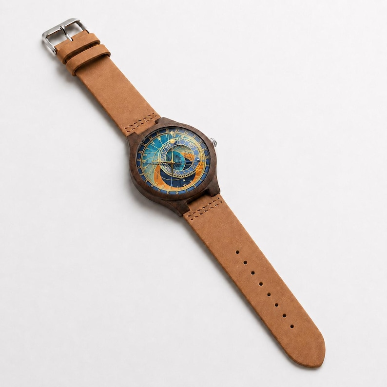Puede incluir: Un reloj de pulsera de madera con una correa de cuero marr&oacute;n claro. La esfera del reloj presenta un dise&ntilde;o celestial detallado con tonos azules, dorados y marrones. El reloj tiene una hebilla plateada y un dise&ntilde;o cl&aacute;sico.