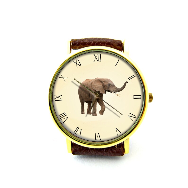 May include: A gold-tone wristwatch with a brown leather band features a white face with Roman numeral hour markers and a picture of an elephant in the center.