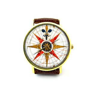 Peut inclure: Une montre dor&eacute;e avec un bracelet en cuir marron. Le cadran de la montre pr&eacute;sente un motif de rose des vents vintage avec des accents rouges, dor&eacute;s et bleus. La montre a une forme ronde classique.