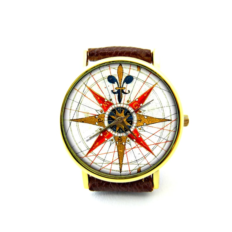 Peut inclure: Une montre dor&eacute;e avec un bracelet en cuir marron. Le cadran de la montre pr&eacute;sente un motif de rose des vents vintage avec des accents rouges, dor&eacute;s et bleus. La montre a une forme ronde classique.