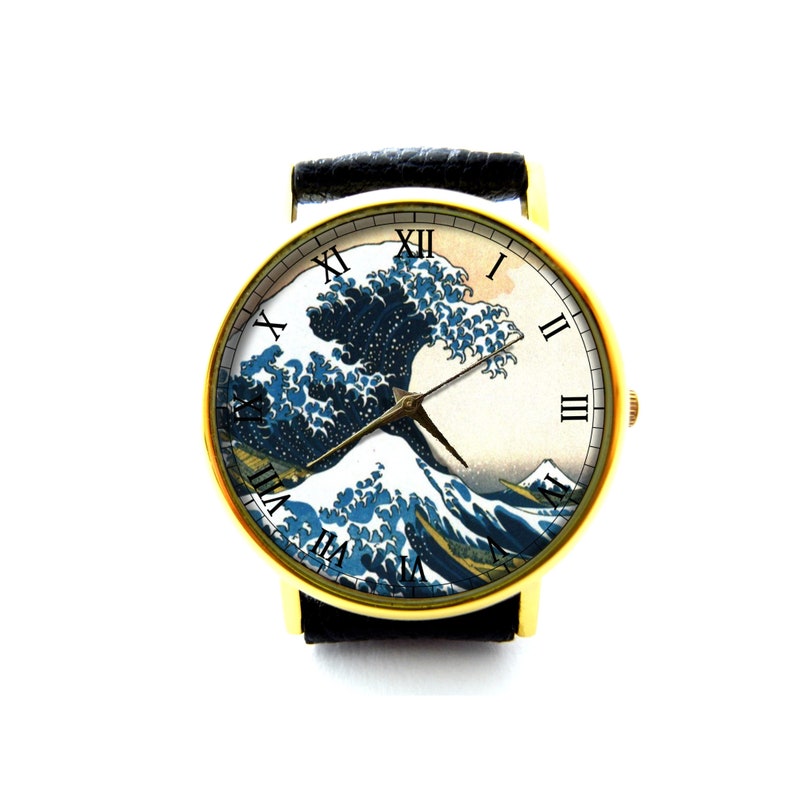 May include: A gold-tone wristwatch with a black leather band features a white face with Roman numeral hour markers and a print of the Great Wave off Kanagawa by Hokusai.