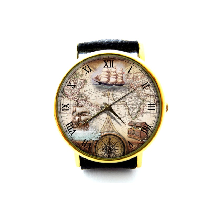 Pu&ograve; includere: Orologio da polso color oro con cinturino in pelle nera. Il quadrante dell'orologio presenta un design a mappa vintage con velieri, una bussola e un forziere. Le ore sono indicate con numeri romani. Un accessorio elegante.