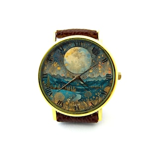 Puede incluir: Un reloj de pulsera de tono dorado con una correa de cuero marr&oacute;n. La esfera del reloj presenta una ilustraci&oacute;n detallada de un paisaje iluminado por la luna con luna llena, monta&ntilde;as y &aacute;rboles.
