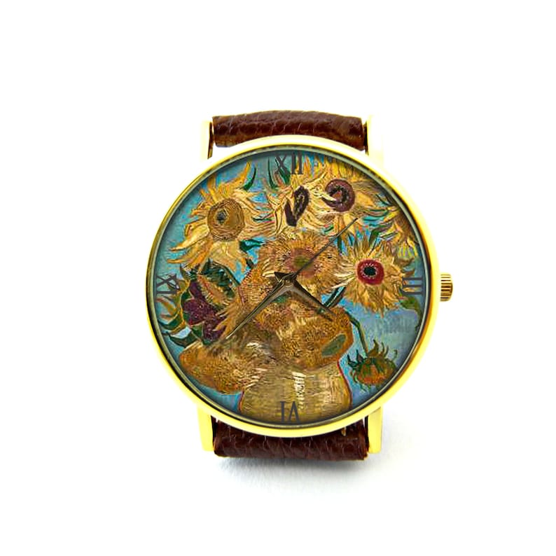 May include: A gold-tone wristwatch with a brown leather band features a colorful painting of sunflowers on the face. The watch face has Roman numeral hour markers.
