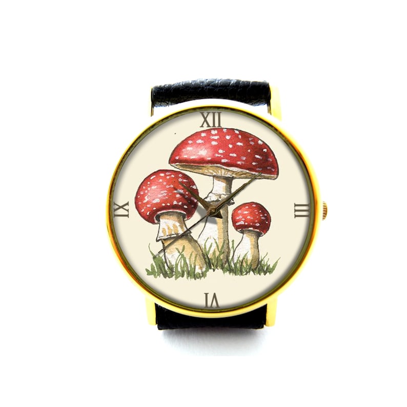 May include: A gold-tone wristwatch with a black leather band features a white face with Roman numeral hour markers and a design of three red and white mushrooms with green foliage.