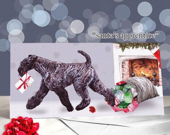 Puede incluir: Tarjeta de Navidad con un perro negro que lleva un regalo en la boca y tira de un saco de regalos. La tarjeta tiene el texto "santa's apprentice" encima de una ilustración de chimenea. Un lazo rojo está en primer plano.