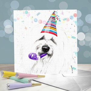 May include: A white dog wearing a colorful party hat and holding a purple party blower. The background is white with confetti and streamers.