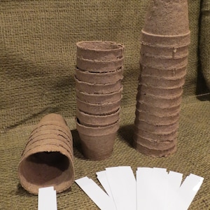 May include: A set of brown biodegradable pots for planting, stacked in two piles, with white plant markers.