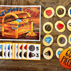 May include: A colorful wooden treasure chest with gold coins and jewels inside. The chest is open and there are several counting cards with different numbers and images of coins, jewels, and a horn. The text "Treasure Count" is written on the top of the image. There is a sign that says "60+ Pieces".