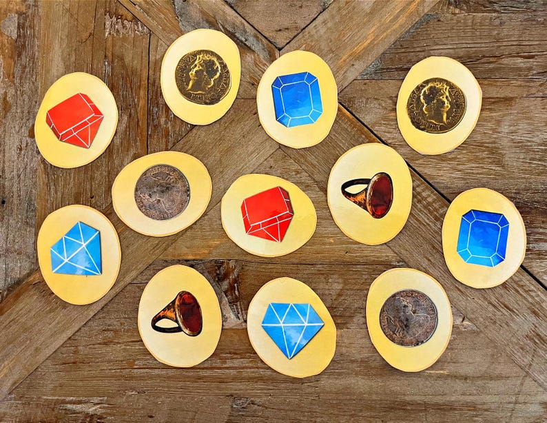 May include: Twelve yellow circular game pieces with various images, including red and blue gems, a gold ring with a red stone, and gold coins.