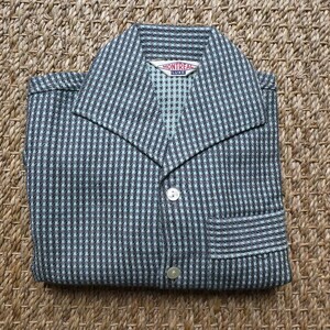 May include: A blue and black checkered shirt with a button-up front and a collar. The shirt has a pocket on the left side and a label that reads "Montreal Luxe".