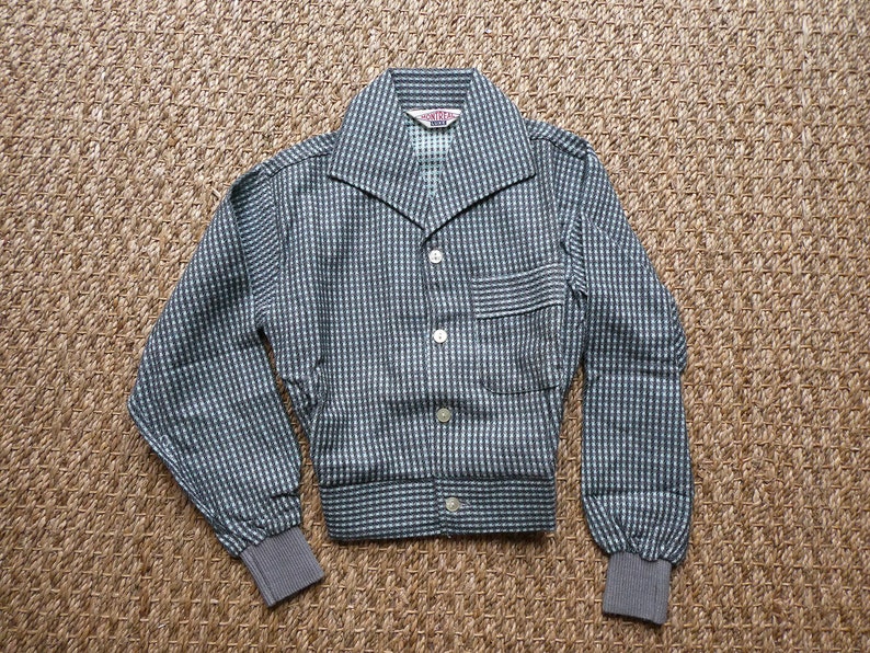 May include: A gray and white checkered button-up shirt with a collar and long sleeves. The shirt has a pocket on the left side and a label that reads "MONTY'S" on the inside of the collar.