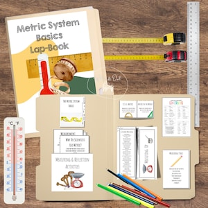 May include: A tan file folder with the text "Metric System Basics Lap-Book" and measuring tools. Includes a thermometer, measuring tapes, and a ruler. The folder contains educational materials about the metric system and measurement activities.