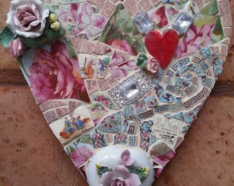 May include: A heart-shaped mosaic made of broken china and other materials. The mosaic is decorated with flowers, rhinestones, and a red heart. The mosaic is signed "Royal Winton China Made in England"
