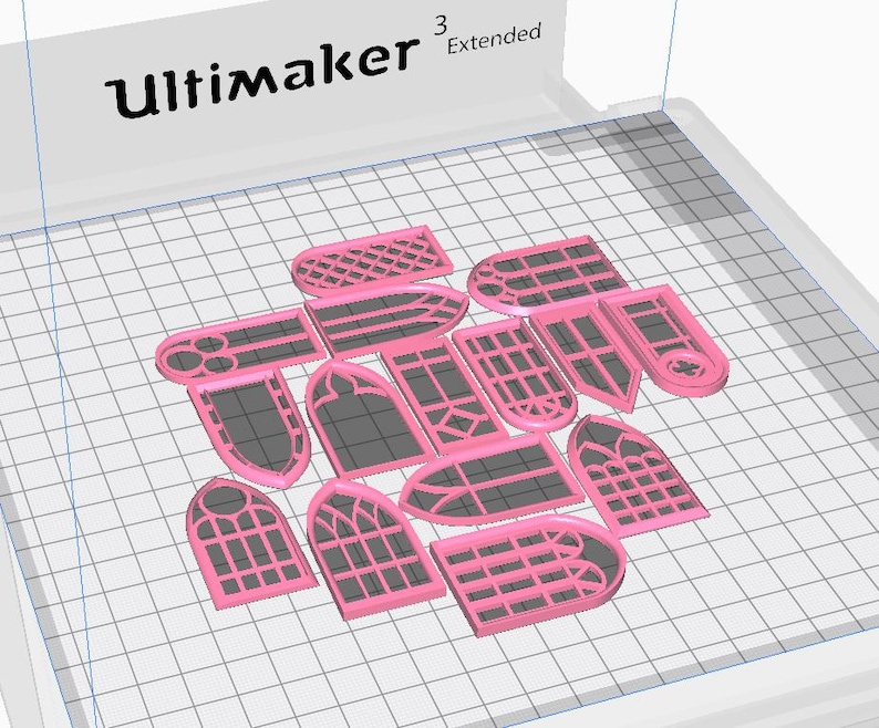 May include: A collection of pink 3D-printed window-shaped objects with various designs, including arched, rectangular, and pointed shapes. The objects are arranged on a grid-patterned surface, with the "Ultimaker" logo visible in the top left corner.