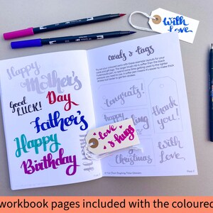 May include: A workbook with pages for practicing calligraphy. The pages feature examples of different greetings and tags, such as "Happy Mother's Day", "Happy Birthday", "Congrats!" and "Thank You!" The workbook is open to a page with the title "Cards & Tags".