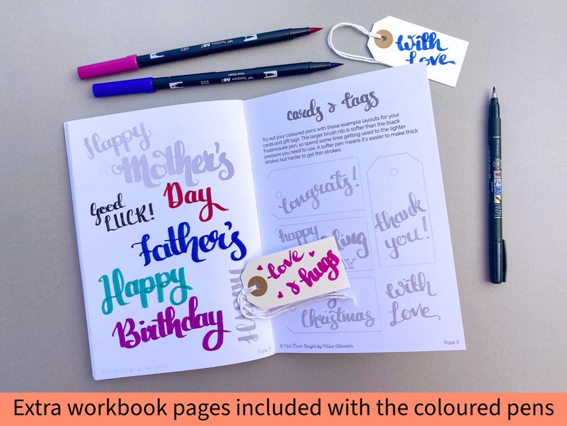May include: A workbook with pages for practicing calligraphy. The pages feature examples of different greetings and tags, such as "Happy Mother's Day", "Happy Birthday", "Congrats!" and "Thank You!" The workbook is open to a page with the title "Cards & Tags".