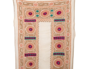 May include: A white fabric wall hanging with a decorative embroidered border. The border features a repeating pattern of circles with pink, green, and red accents.