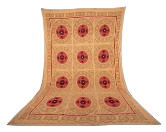 May include: A large, cream-colored textile with a repeating pattern of red and black floral motifs. The textile is folded in half and has a fringed edge.