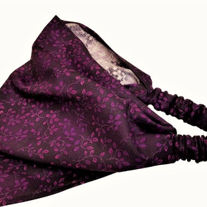May include: A purple headband with a floral pattern. The headband is made of a soft, stretchy fabric and has a comfortable fit.