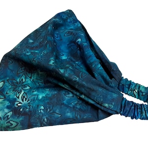May include: A teal blue headband with a floral pattern. The headband has a stretchy elastic band.