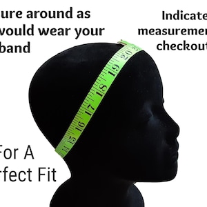May include: A black mannequin head with a green measuring tape wrapped around it. The tape measures from 14 to 20 inches. Text on the image reads, "Measure around as you would wear your headband" and "For A Perfect Fit."