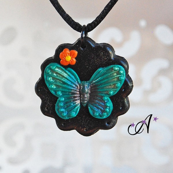 Collier pendentif médaillon noir, papillon turquoise et fleur orange réalisé à l'argile polymère fimo, corde de satin noir 2mm