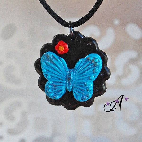 Collier pendentif médaillon noir, papillon bleu et fleur rose réalisé à l'argile polymère fimo, corde de satin noir 2mm