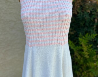 May include: A sleeveless, white and pink striped knit dress. The top portion features vertical stripes of white and light pink. The bottom half is a solid white, flared skirt. The dress is displayed on a mannequin.