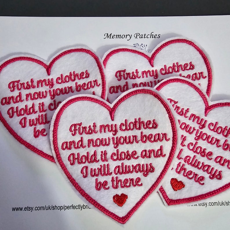 Op de afbeelding: Vijf rode hartvormige viltpatches met witte borduursels. De tekst op de patches luidt "First my clothes and now your bear. Hold it close and I will always be there."