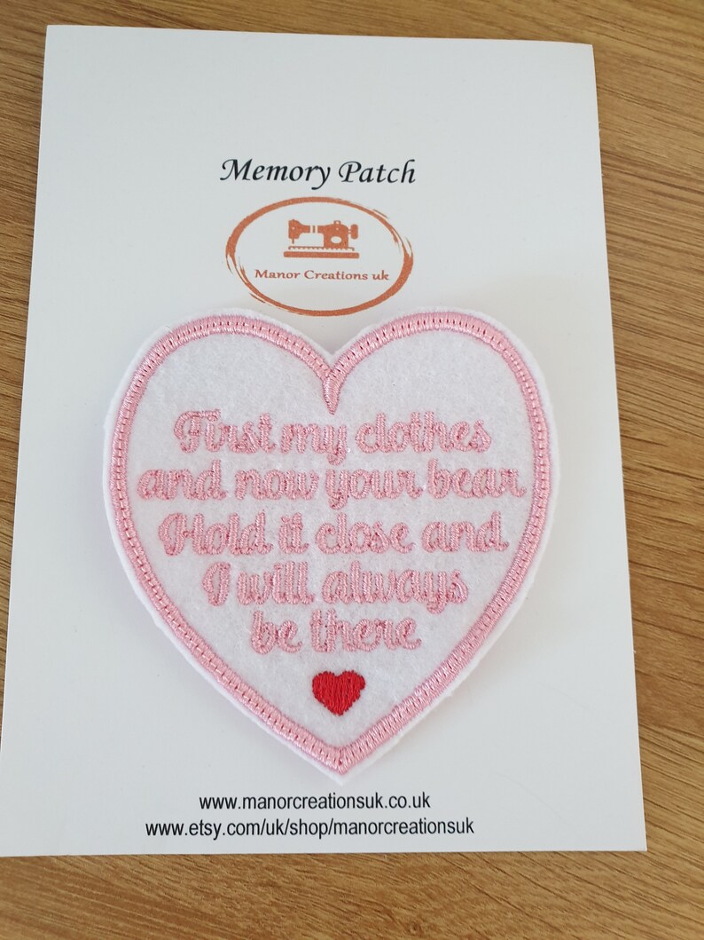 Op de afbeelding: Roze gestikte hartvormige patch met de tekst "First my clothes and now your bean. Hold it close and I will always be there."