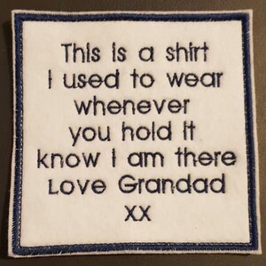 Puede incluir: Parche cuadrado blanco con borde azul marino. El parche presenta texto bordado que dice "This is a shirt I used to wear whenever you hold it know I am there Love Grandad XX."