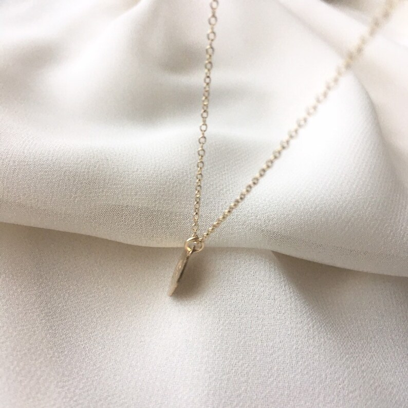 May include: A gold chain necklace with a small, round pendant.