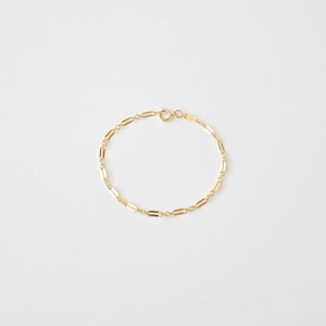 Peut inclure: Un bracelet en cha&icirc;ne dor&eacute;e avec un design d&eacute;licat de maillons rectangulaires.