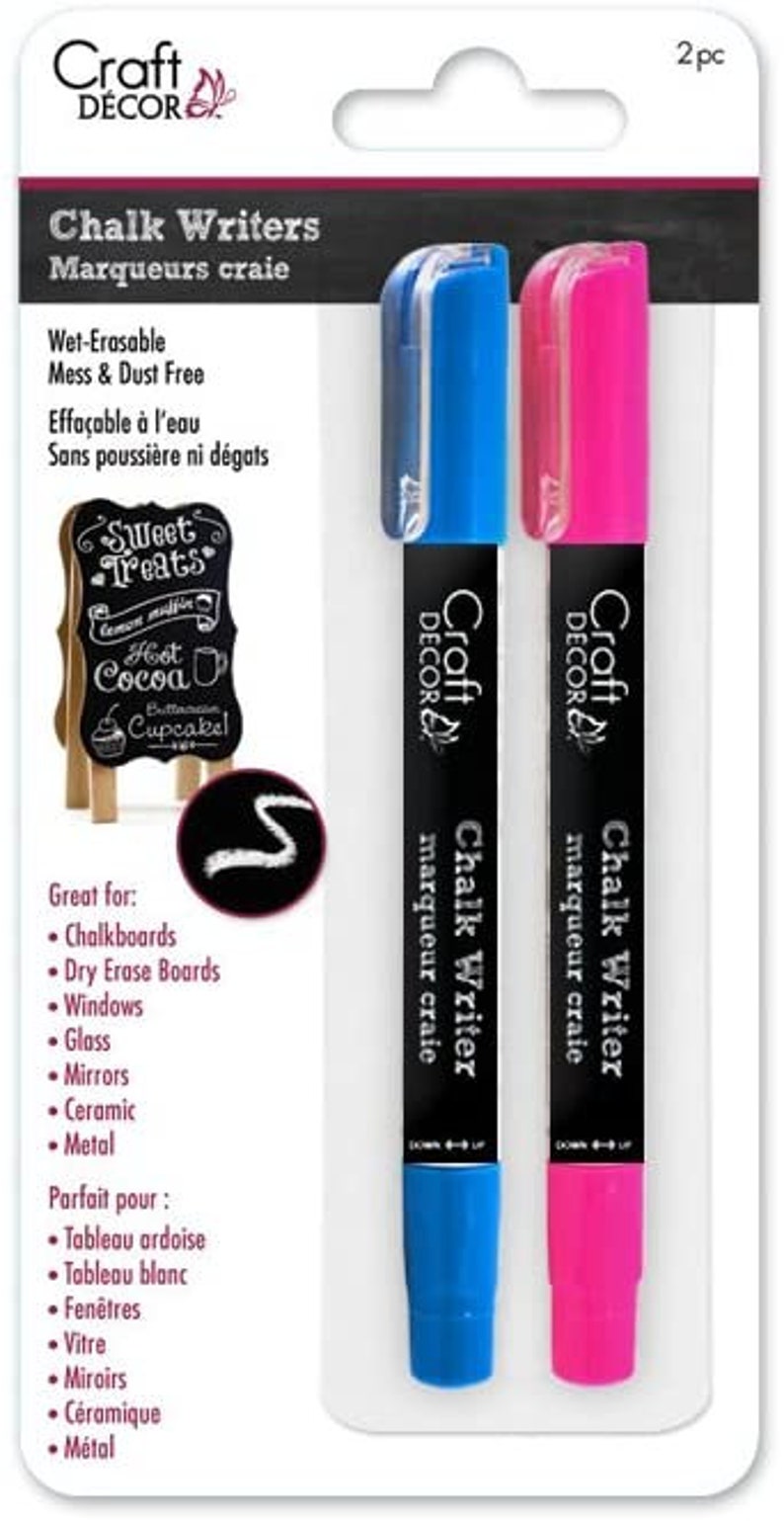 May include: Two-pack of Craft Decor chalk writers. One marker is blue, the other is pink. The markers are wet-erasable and mess-free. The packaging also shows a small chalkboard sign with the words "Sweet Treats".