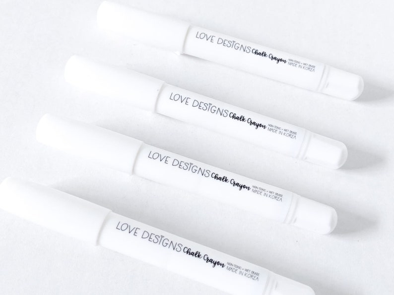 May include: Four white chalk crayons with black labels that read "LOVE DESIGNS Chalk Crayon NON-TOXIC - WET ERASE MADE IN KOREA".