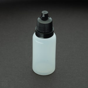 May include: A clear plastic bottle with a black dropper top. The bottle is empty and has a textured surface.