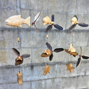 Animais marinhos esculpidos em madeira, cata-vento à prova de UV/intempéries, hélices de penas reais mutáveis.