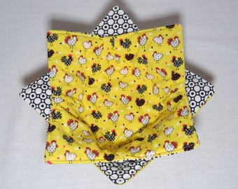 May include: A yellow fabric bowl with a black and white geometric pattern on the outside and a pattern of black and white chickens on a yellow background on the inside.