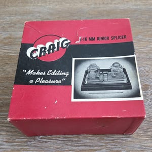 May include: A vintage red box with the name "Craig" in white lettering and the text "Makes Editing a Pleasure." The box features a black and white image of a film splicer. The box is for a 16 mm Junior Splicer.