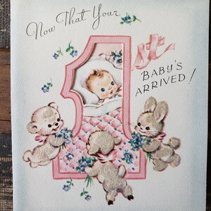 Op de afbeelding: Vintage geboortekaartje in roze en wit. De kaart toont een baby in een roze nummer &eacute;&eacute;n, omringd door cartoon dieren en de tekst "Now That Your Baby's Arrived!" in een sierlijk lettertype.