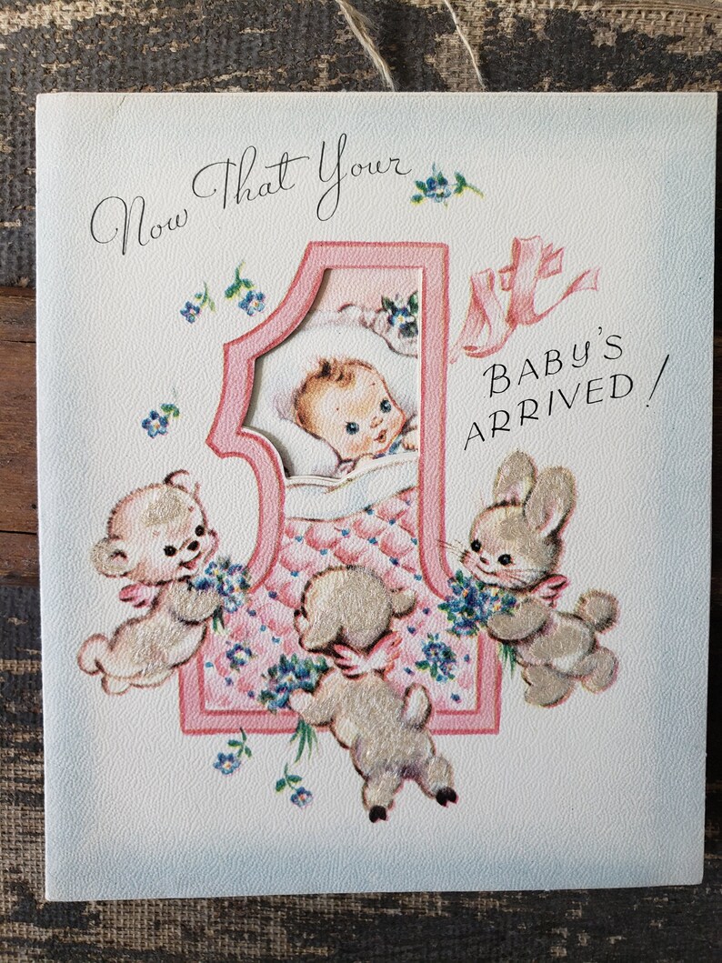 Op de afbeelding: Vintage geboortekaartje in roze en wit. De kaart toont een baby in een roze nummer &eacute;&eacute;n, omringd door cartoon dieren en de tekst "Now That Your Baby's Arrived!" in een sierlijk lettertype.