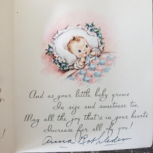 Op de afbeelding: Vintage baby wenskaart. De kaart toont een handgetekende illustratie van een baby in een witte muts, omringd door blauwe bloemen, op een roze en blauw geruite deken. De handgeschreven tekst luidt: "En als je kleine baby groeit..."